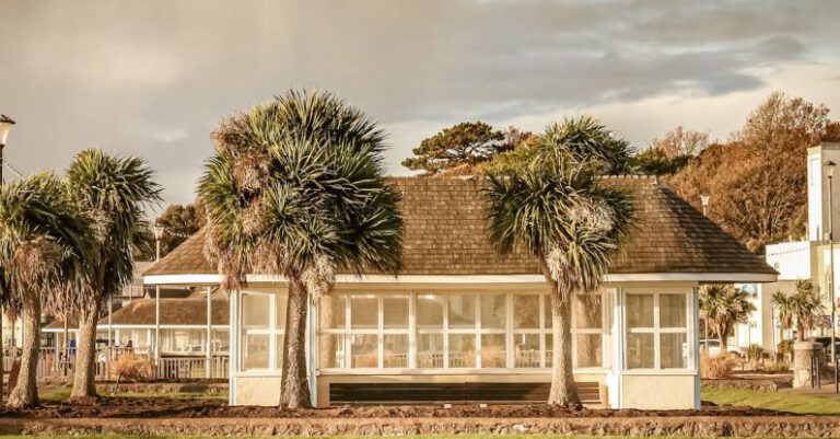 Beachfront Accommodations - Small white construction on grassland on cloudy day
