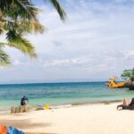 Sustainable Beach Activities - Man cleaning tropical sandy beach