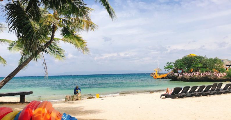 Sustainable Beach Activities - Man cleaning tropical sandy beach