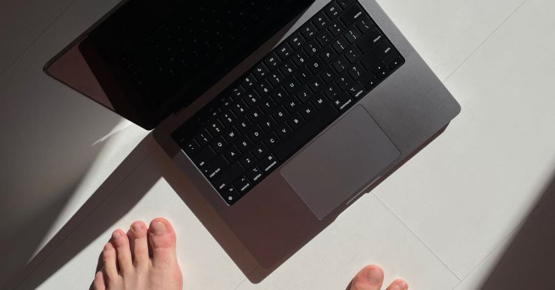 First-Class - Macbook Pro 14 keyboard at an angle in sunlight