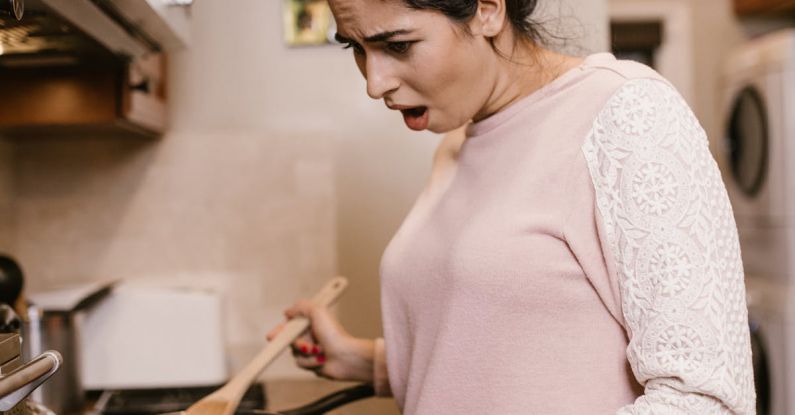 Cooking Classes - A Woman Looking at a Laptop while Cooking