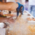 Street Food - Person in Orange Shirt Holding Aluminum Rectangular Container