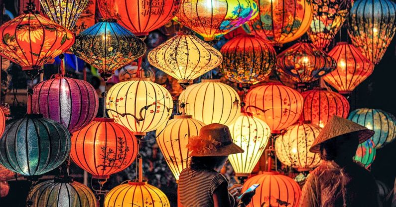 Culture - Two Person Standing Near Assorted-color Paper Lanterns