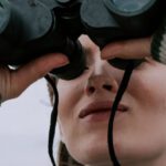 Ecotourism - A Woman Looking Through Binoculars