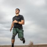 Fitness - Man Running on Sand Field