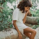 Kid-Friendly - Girl Sitting on a Fallen Tree Trunk