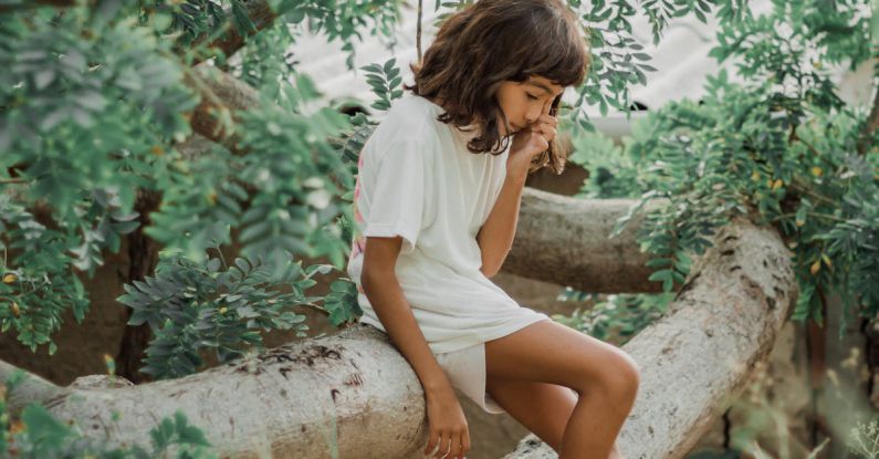 Kid-Friendly - Girl Sitting on a Fallen Tree Trunk