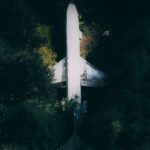 Break Down - Drone view of modern white broken abandoned plane crashed in green dense forest